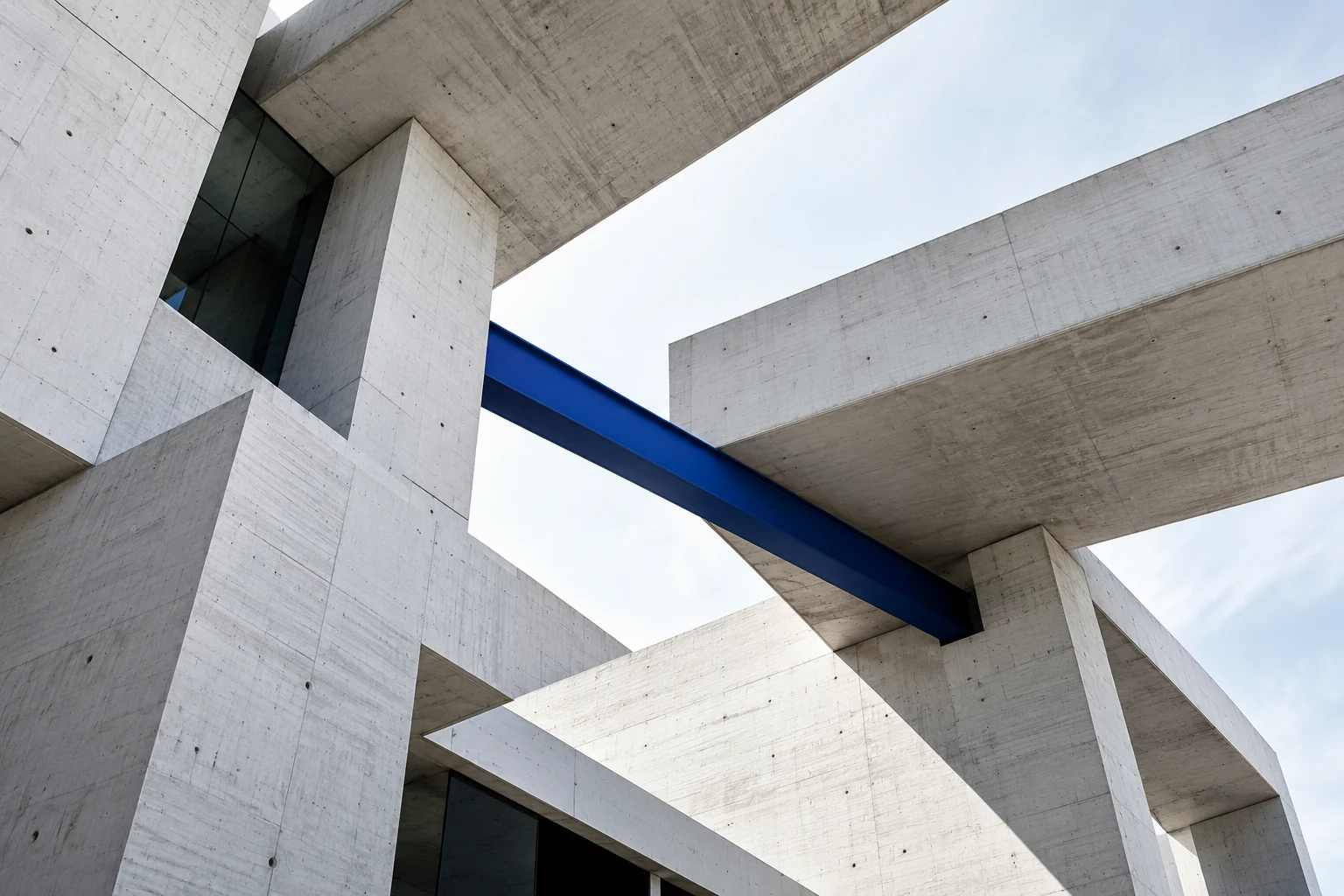 Intersecting white architectural planes and a cobalt structural beam